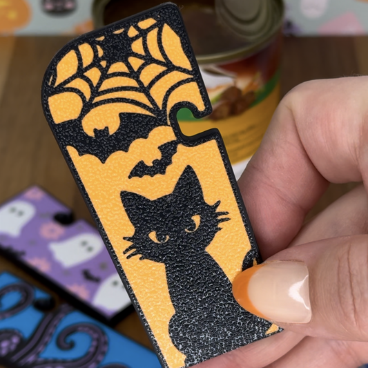 Halloween-themed Tab Buddy XL with a black cat design held by a hand.