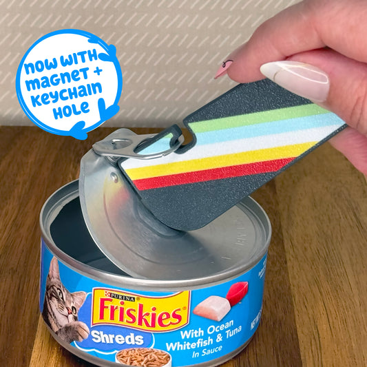 Person using a colorful Tab Buddy XL to open a can of Purina Friskies cat food, text reads 'now with magnet + keychain hole'