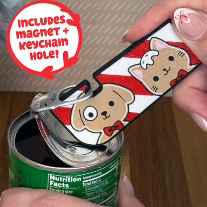 Cute gingerbread dog and cat design Tab Buddy XL is used to open a can. Text notes the Tab Buddy XL includes a magnet and keychain hole.