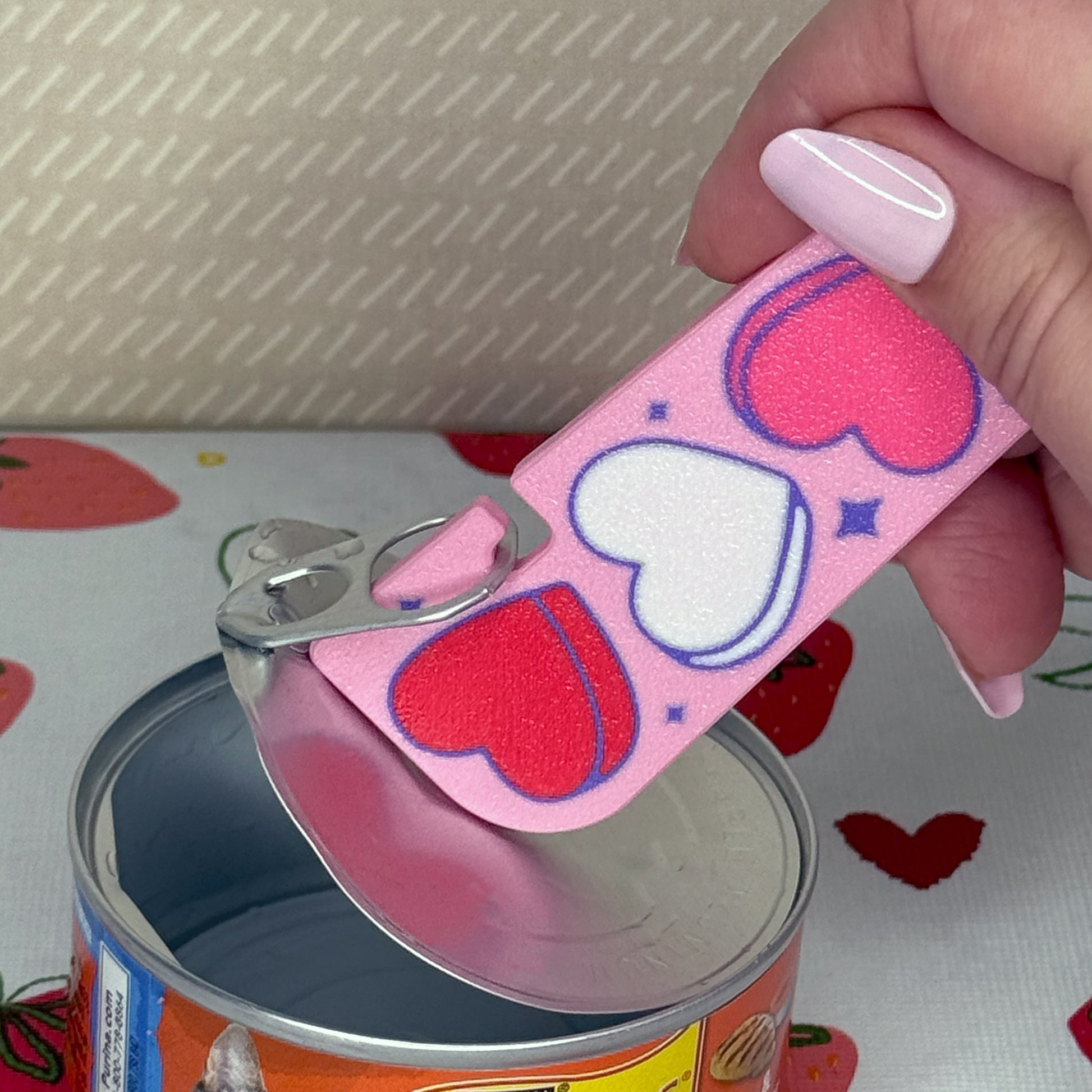 Pink Tab Buddy XL with heart designs being used on a can with a patterned background
