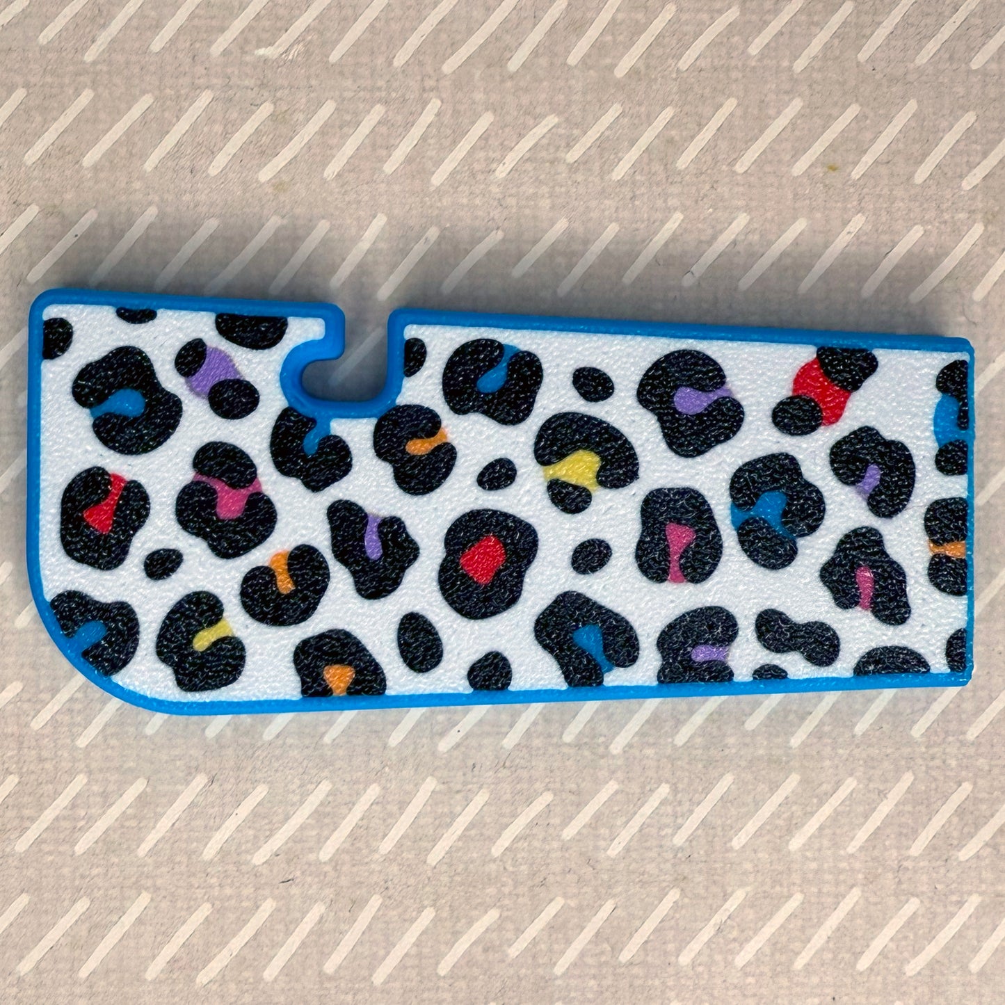 Rainbow leopard print Tab Buddy XL rests on a beige surface