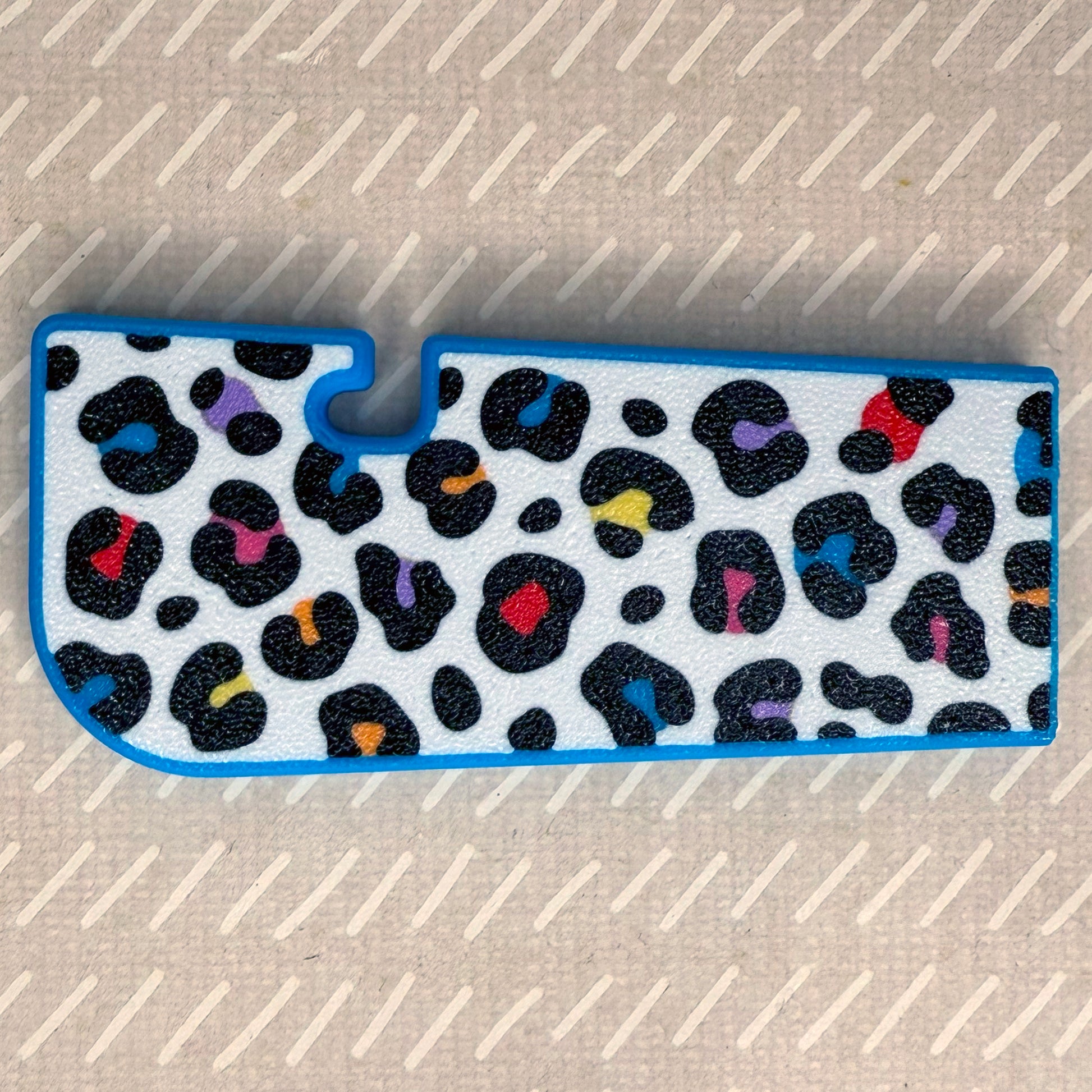 Rainbow leopard print Tab Buddy XL rests on a beige surface