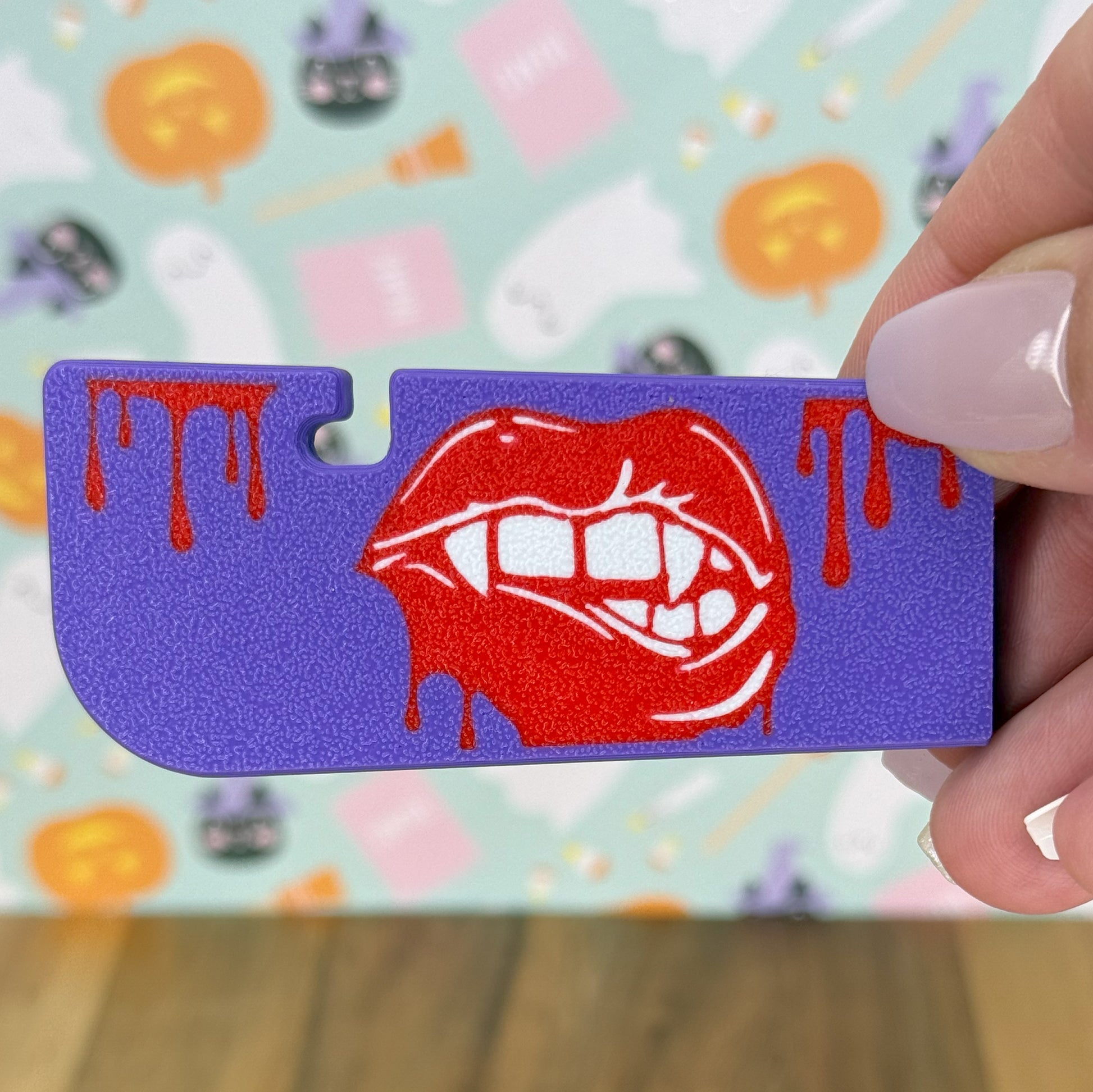 Tab Buddy XL with red lips on purple background held by a hand