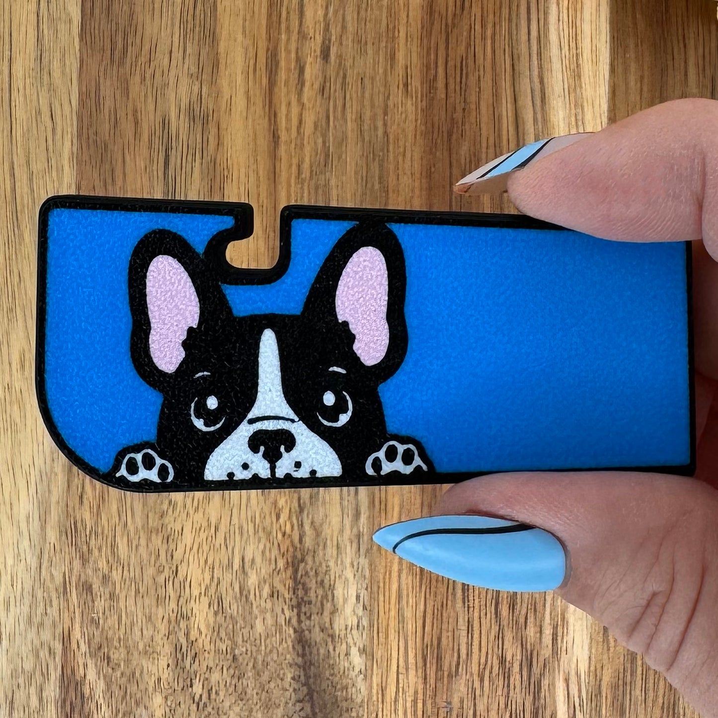 Blue Tab Buddy XL with a dog design held by a hand on a wooden surface