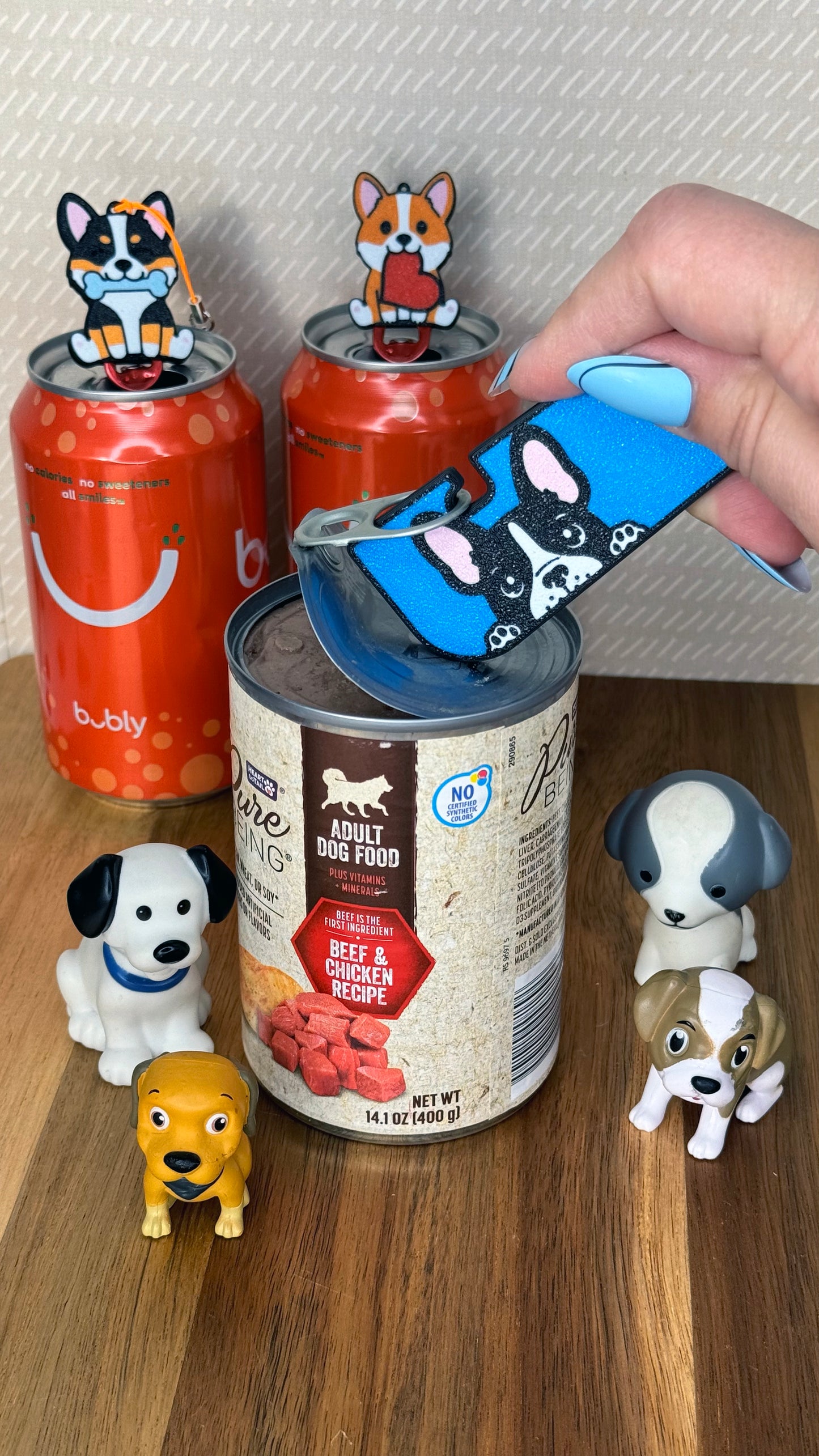 Person using a Tab Buddy XL on a can of dog food with small dog figurines around.