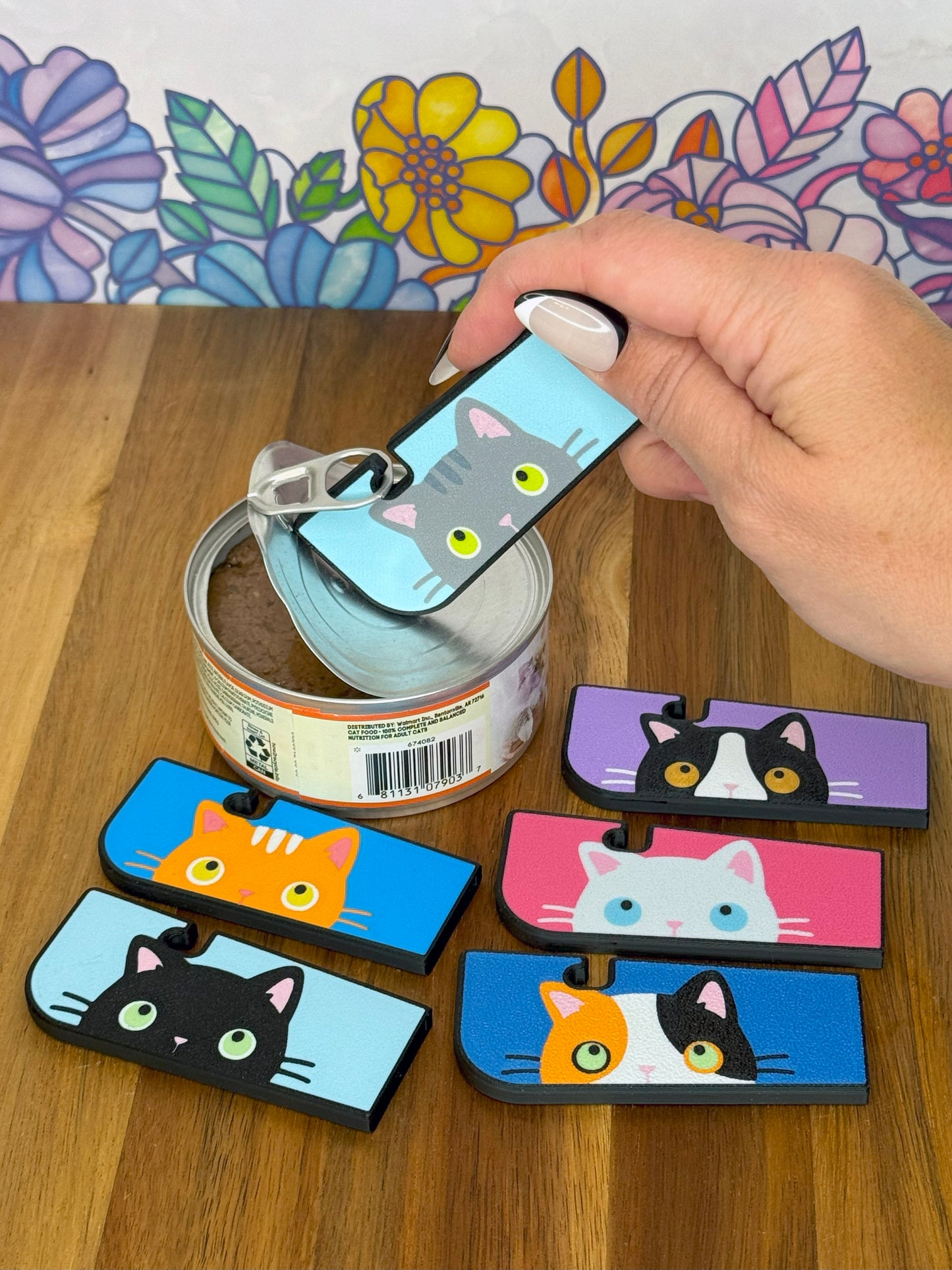 Cat-themed Tab Buddy XL on a wooden surface with a floral background