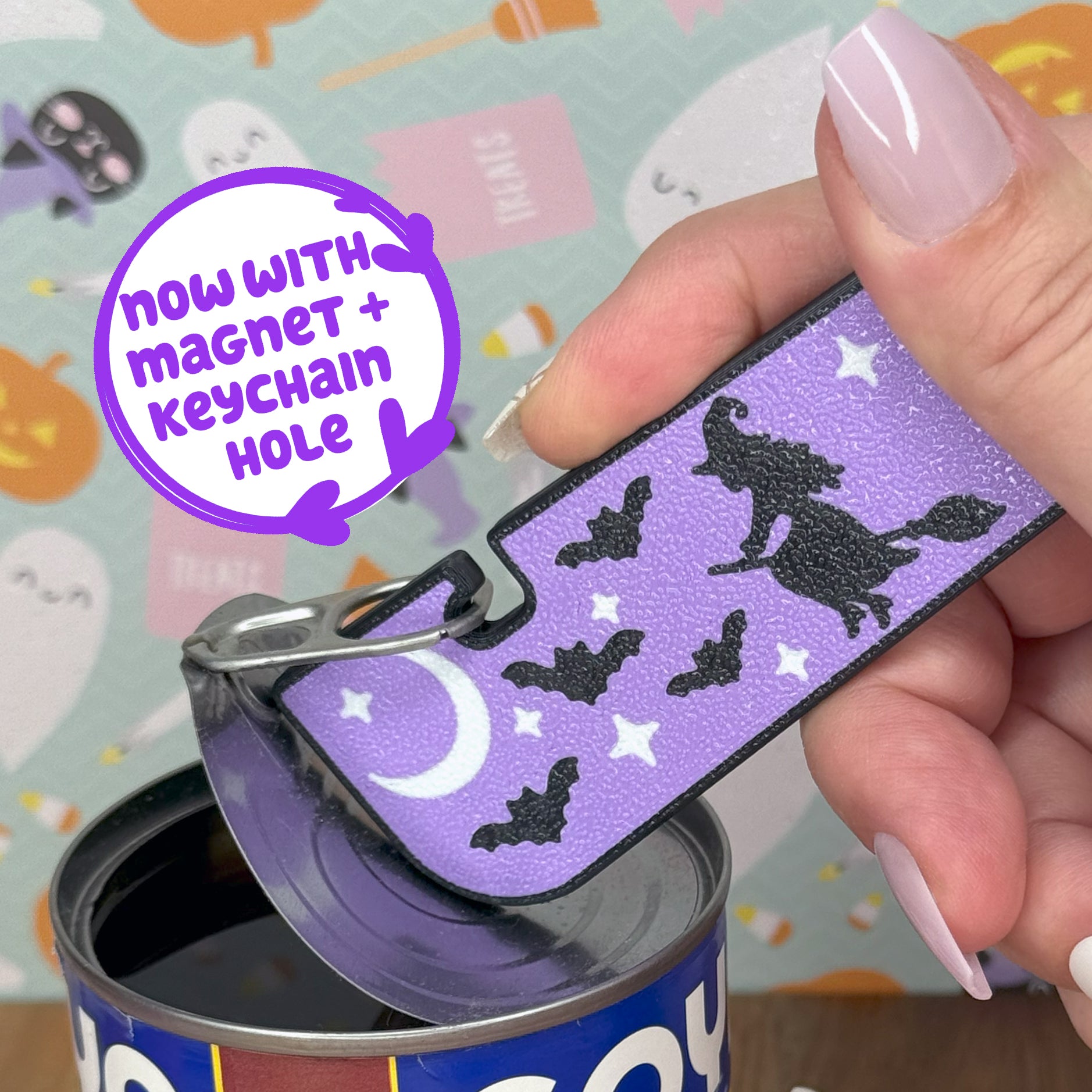 Purple Tab Buddy XL with witch and bat design, opening a can, on a colorful Halloween-themed background.